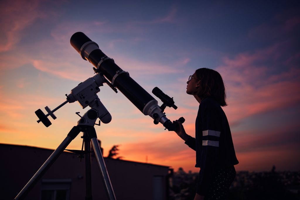 Girl,With,Astronomical,Telescope,Stargazing,Under,Twilight,Sky.